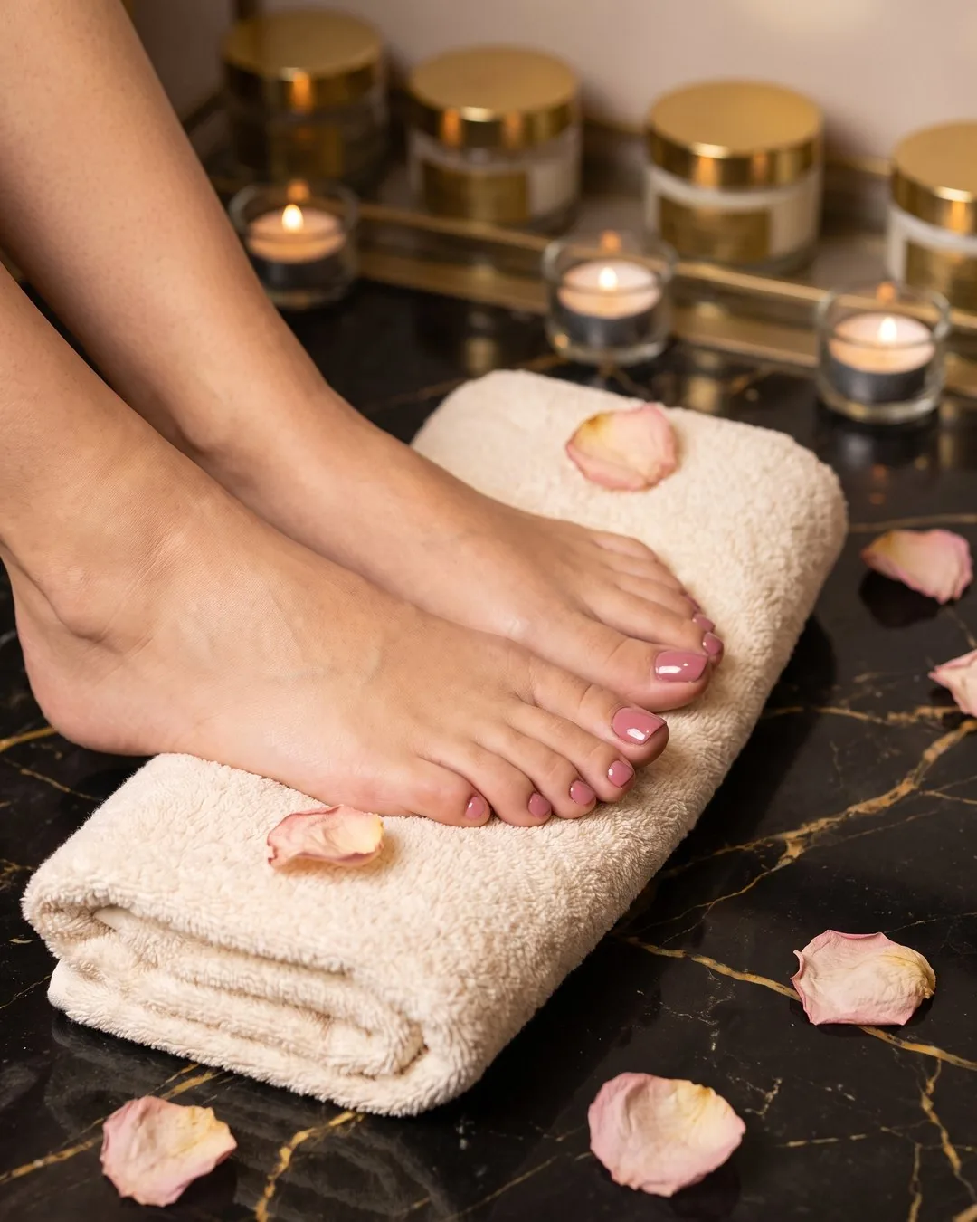 Pies con gelish rosa sobre una toalla, pedicure en seco