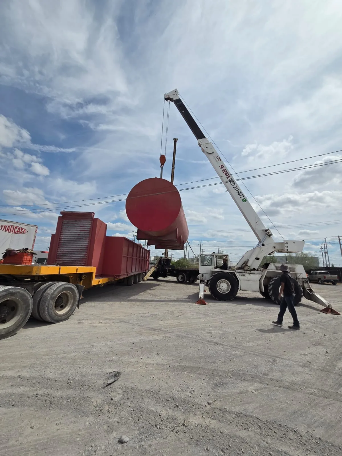 Izaje de un tanque de acero junto a un lowboy, con grúa todo terreno