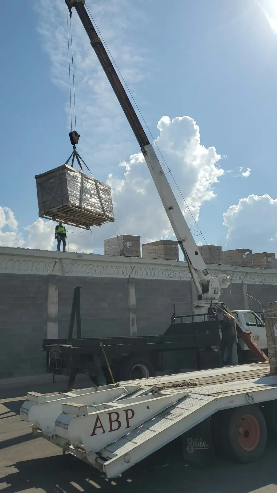 Subida de tarimas a la azotea de una nave, con grúa titán