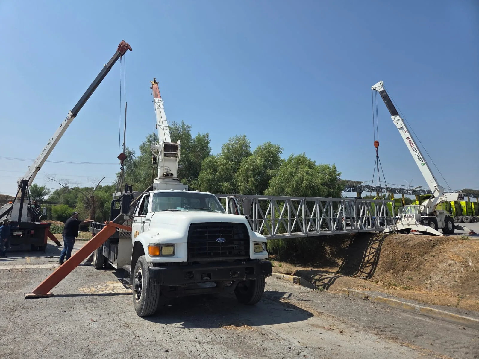 Colocación de un puente peatonal sobre un canal, con maniobra coordinada a tres grúas