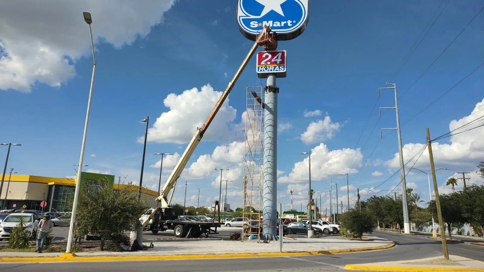 Servicio al anuncio de pilón de S-Mart sobre avenida, con canastilla